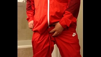 Returning in a red Nike windsuit